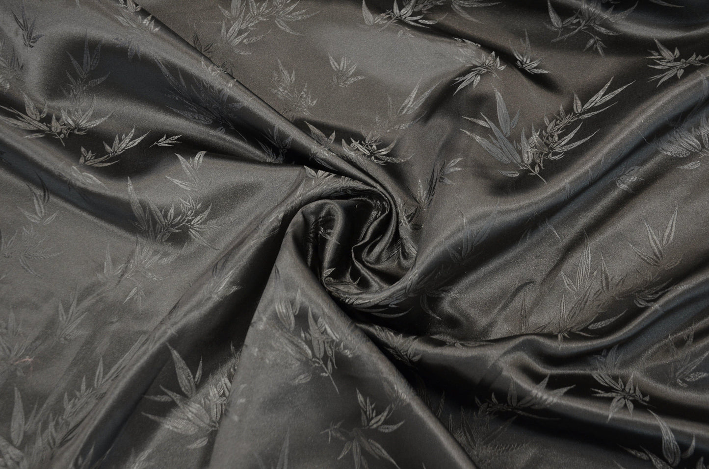 black fabric with subtle leaf pattern