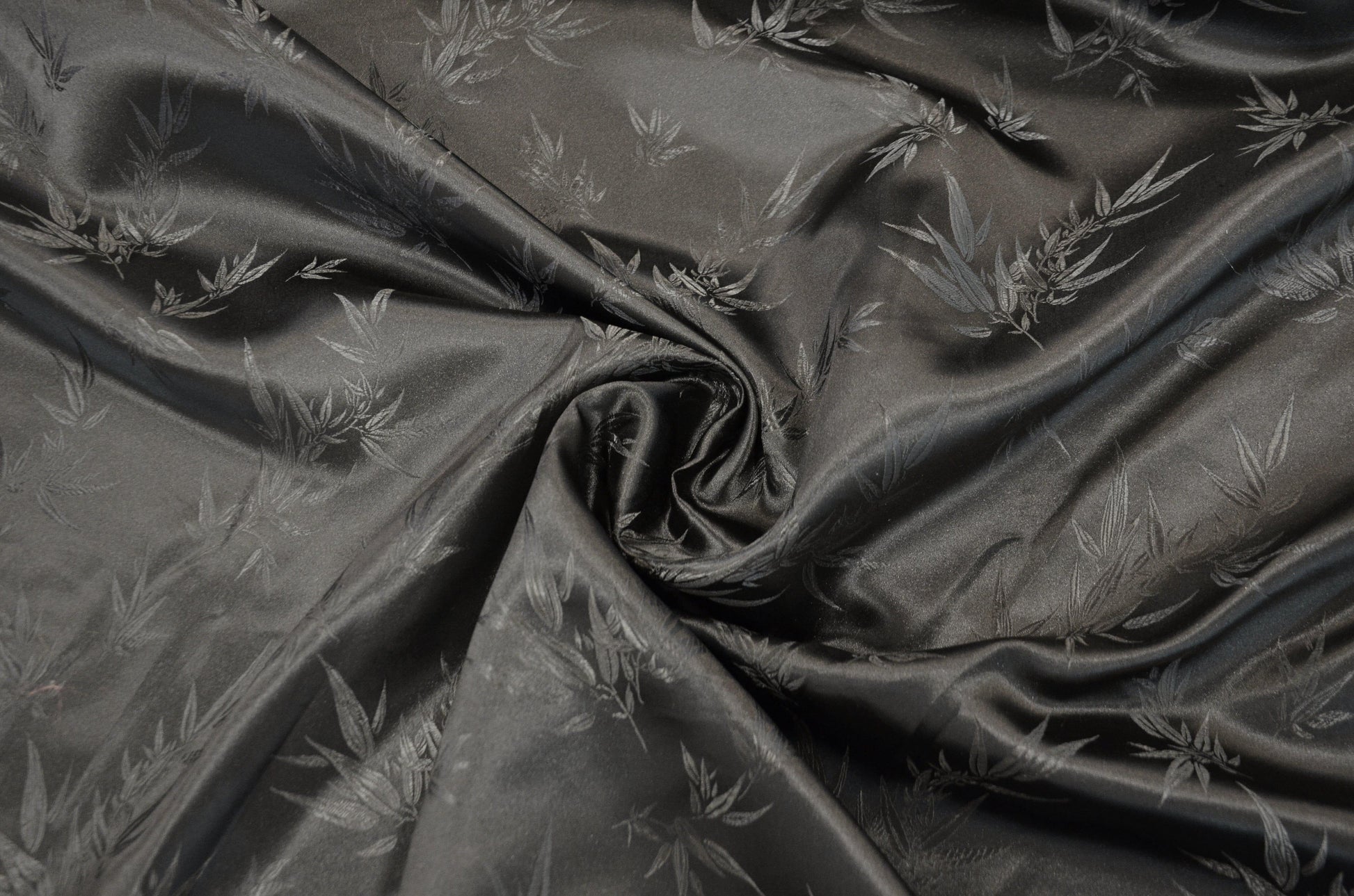 black fabric with subtle leaf pattern