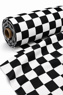 A roll of black and white checkered pattern material, partially unrolled to show the fabric or paper texture, on a clean white background.