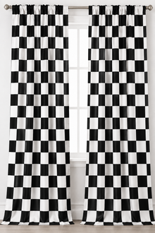 Black and white checkered curtain panels hanging from a silver rod over a window.