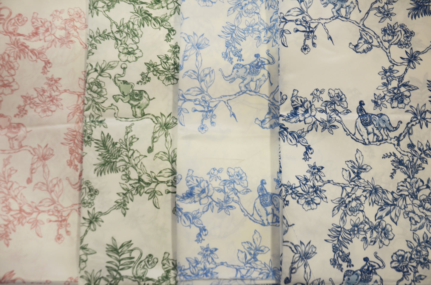 A collection of satin print drapery panels displayed in three rows, with the top row featuring a red floral pattern, the middle row a blue floral pattern, and the bottom row a green floral pattern. Each panel is folded to show both sides of the fabric.