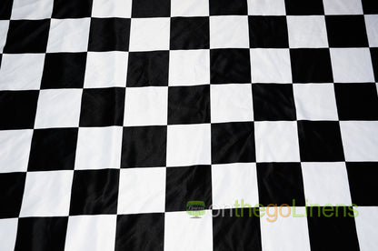 Close-up of a checkered pattern fabric with a satin finish, predominantly white and black.